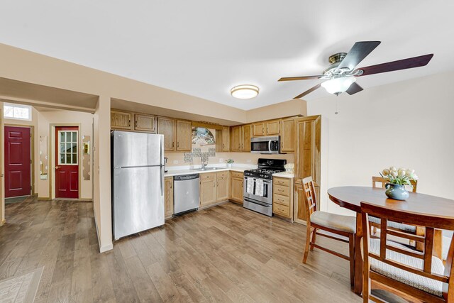 26247 N Green St Unit 2F, Mundelein, IL 60060 - kitchen featuring a sink, light countertops, ceiling fan, light wood-style flooring, and appliances with stainless steel finishes