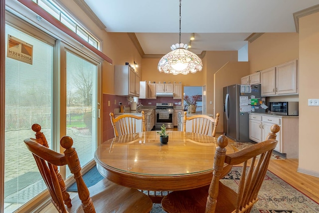 851 Bluestem Dr, Bolingbrook, IL 60440 - dining space featuring light wood finished floors, a notable chandelier, and ornamental molding