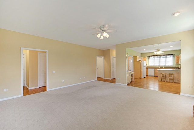 9154 Arbour Walk Dr, Frankfort, IL 60423 - unfurnished living room with ceiling fan, light carpet, baseboards, and light wood finished floors