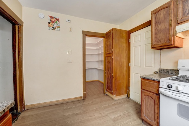 5048 W Wrightwood Ave, Chicago, IL 60639 - kitchen featuring white gas stove, light wood-type flooring, and brown cabinetry