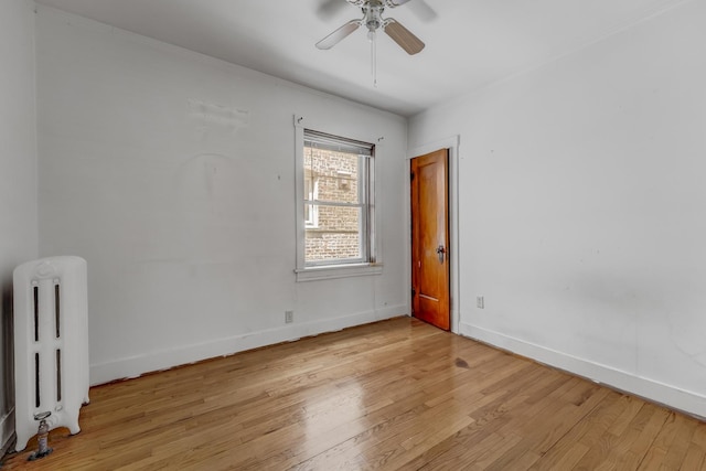 5048 W Wrightwood Ave, Chicago, IL 60639 - spare room with radiator heating unit, light wood finished floors, and ceiling fan