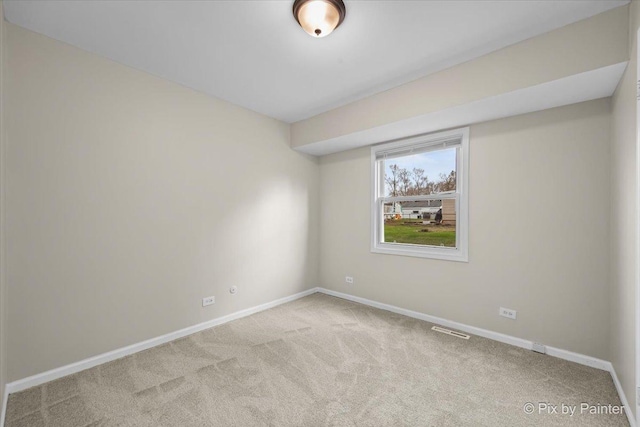 empty room featuring carpet flooring, visible vents, and baseboards