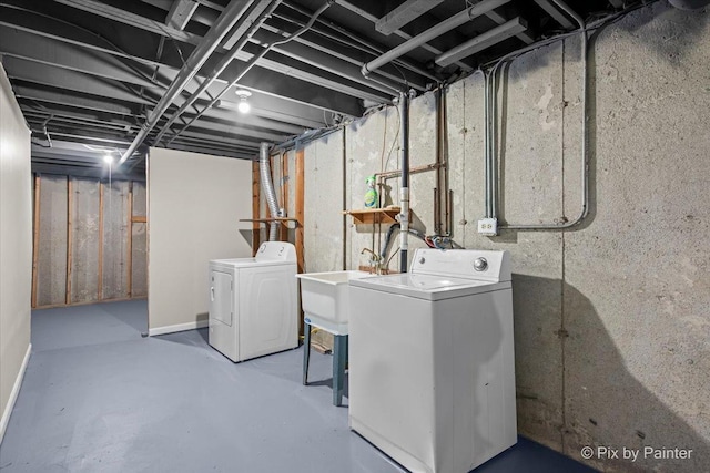 clothes washing area featuring a sink, washing machine and dryer, and laundry area