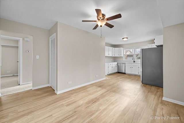 unfurnished living room featuring a sink, baseboards, and a ceiling fan