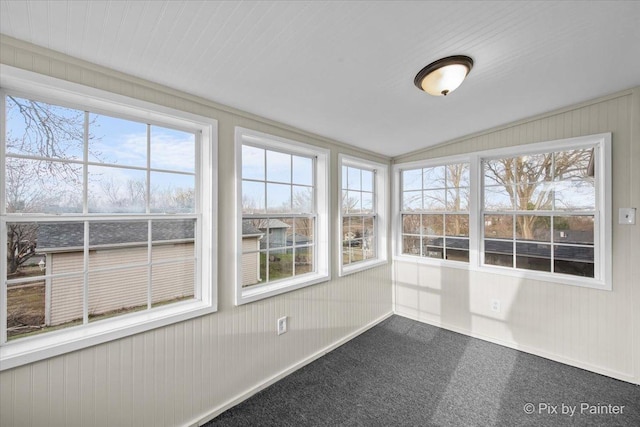 unfurnished sunroom featuring baseboards, carpet flooring, and lofted ceiling