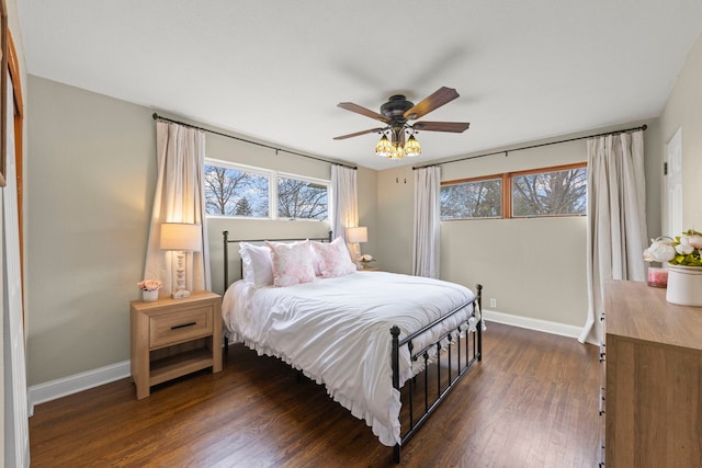 bedroom featuring baseboards, a ceiling fan, and dark wood finished floors