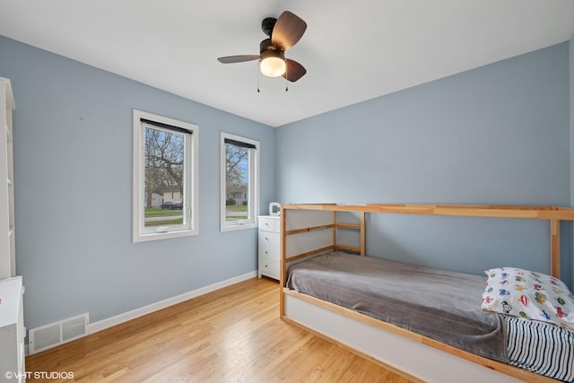bedroom with visible vents, baseboards, ceiling fan, and wood finished floors