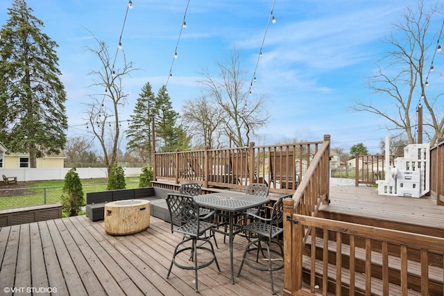 wooden deck featuring a fire pit and fence