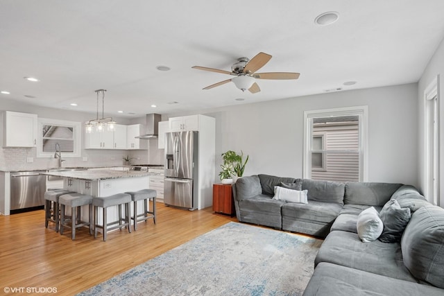 living area with visible vents, ceiling fan, light wood-type flooring, and recessed lighting