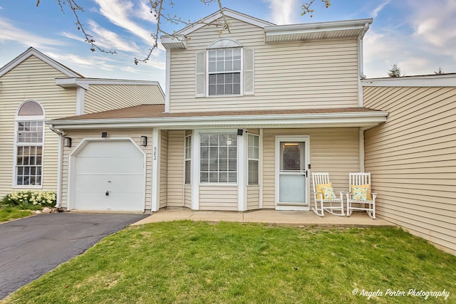 traditional-style home with an attached garage, driveway, and a front yard