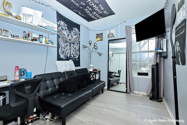 living area with baseboards and wood finished floors