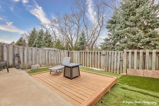 wooden terrace featuring a fenced backyard and a lawn