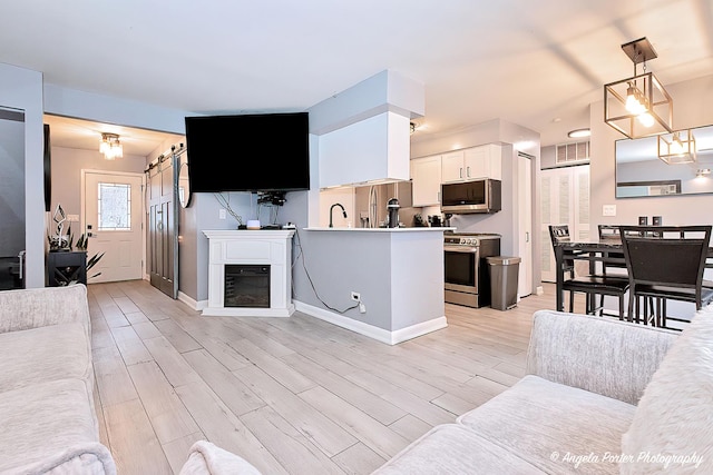 living room with visible vents, baseboards, and light wood-type flooring