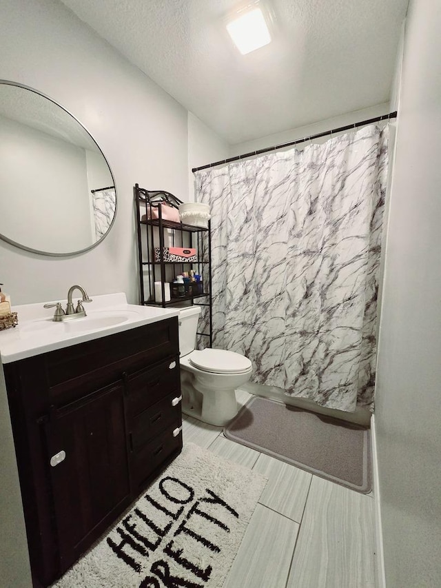 bathroom with toilet, a textured ceiling, vanity, and a shower with curtain