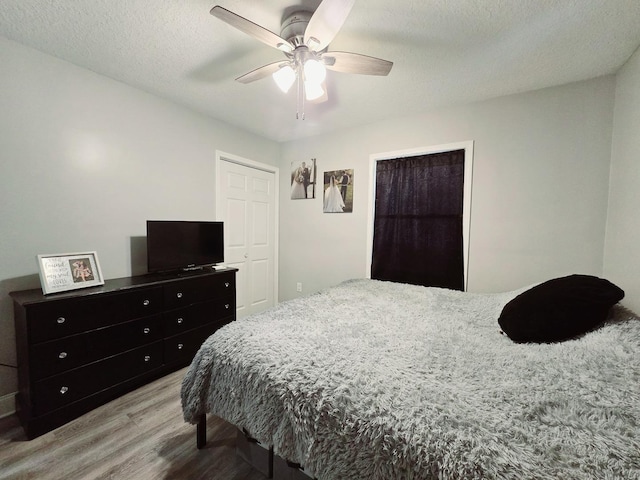 bedroom featuring a textured ceiling, light wood finished floors, and ceiling fan