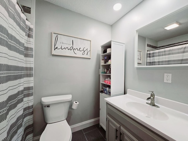 bathroom with toilet, vanity, baseboards, and a shower with curtain
