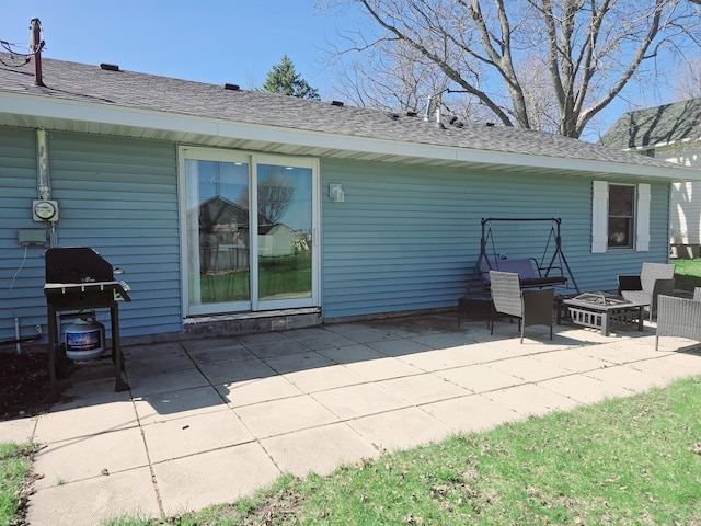 back of property featuring a patio and roof with shingles