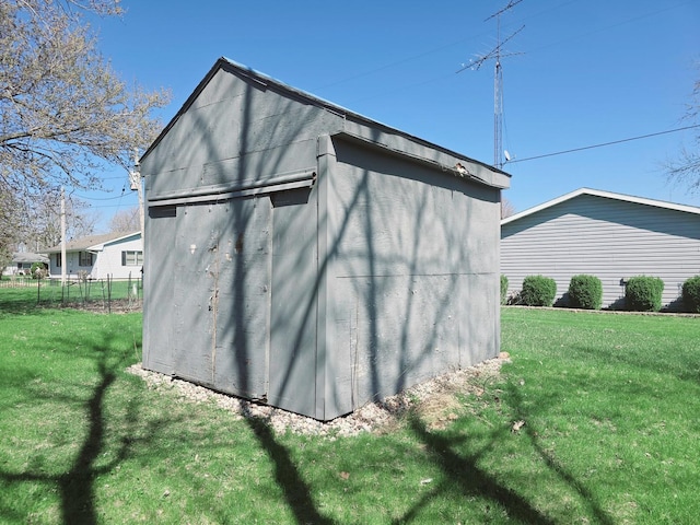 view of outdoor structure featuring fence and an outbuilding