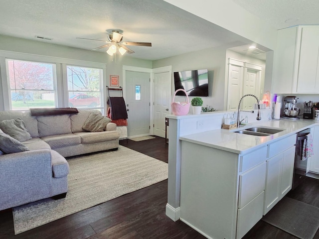 kitchen featuring dark wood-type flooring, ceiling fan, a sink, and white cabinets