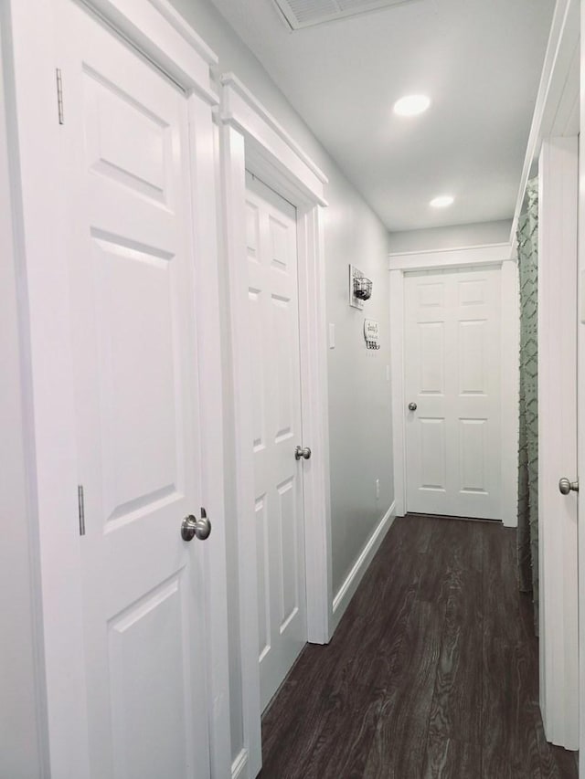 hall with dark wood-type flooring, baseboards, and recessed lighting