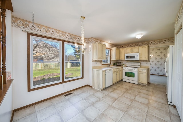 kitchen featuring baseboards, wallpapered walls, white appliances, light countertops, and visible vents