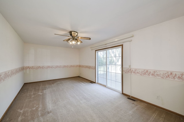 carpeted empty room featuring visible vents and a ceiling fan
