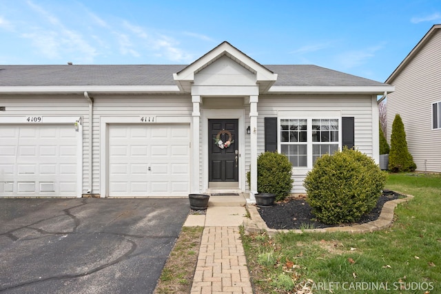 view of front of home featuring roof with shingles and aphalt driveway