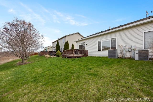 rear view of property with a lawn, central AC, and a deck