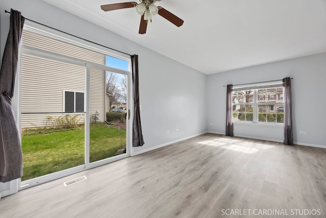 empty room with baseboards, wood finished floors, visible vents, and ceiling fan