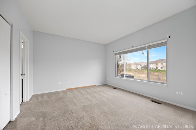 carpeted spare room with baseboards and visible vents