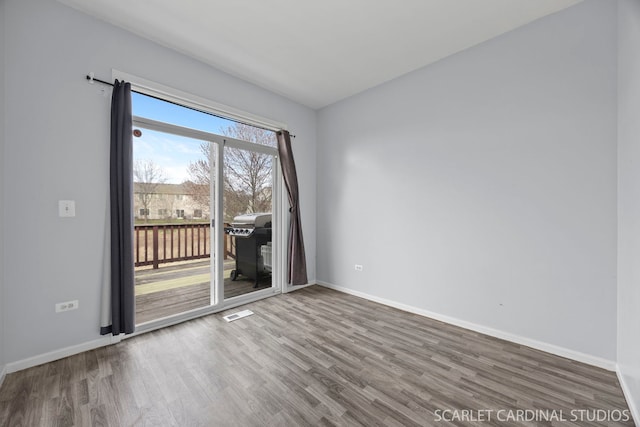 unfurnished room featuring baseboards and wood finished floors
