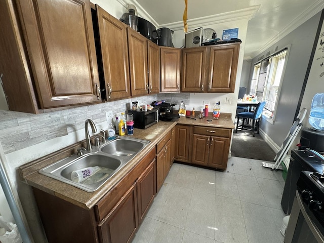 kitchen with a sink, ornamental molding, backsplash, and light tile patterned floors