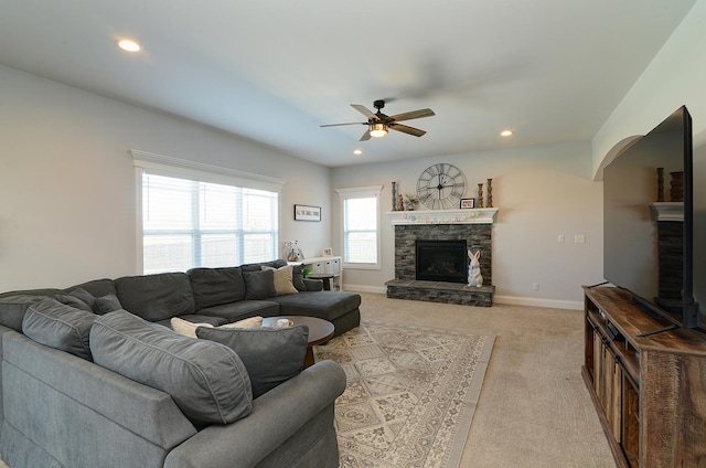 living room with baseboards, a stone fireplace, recessed lighting, a ceiling fan, and light colored carpet