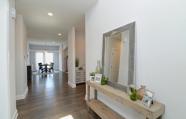 hallway with baseboards, recessed lighting, and dark wood finished floors