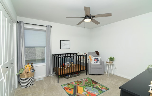 bedroom featuring a nursery area, a closet, visible vents, carpet floors, and baseboards