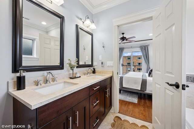 ensuite bathroom with double vanity, a sink, ornamental molding, and ceiling fan
