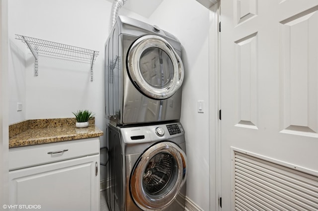 laundry area featuring stacked washer / drying machine and laundry area