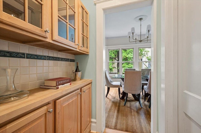 820 Lake Ave, Wilmette, IL 60091 - kitchen with a chandelier, tasteful backsplash, glass insert cabinets, wooden counters, and light wood finished floors