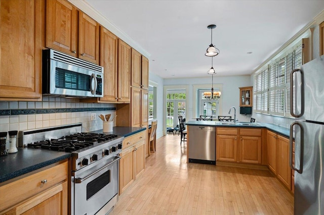820 Lake Ave, Wilmette, IL 60091 - kitchen featuring appliances with stainless steel finishes, a peninsula, backsplash, dark countertops, and a sink