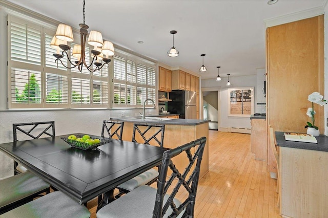 820 Lake Ave, Wilmette, IL 60091 - dining area featuring a baseboard heating unit, a chandelier, light wood-style floors, and crown molding
