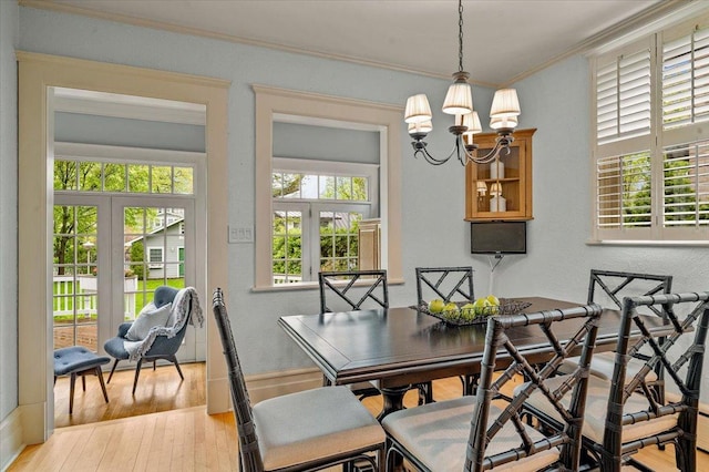 820 Lake Ave, Wilmette, IL 60091 - dining area featuring crown molding, a chandelier, french doors, and light wood finished floors