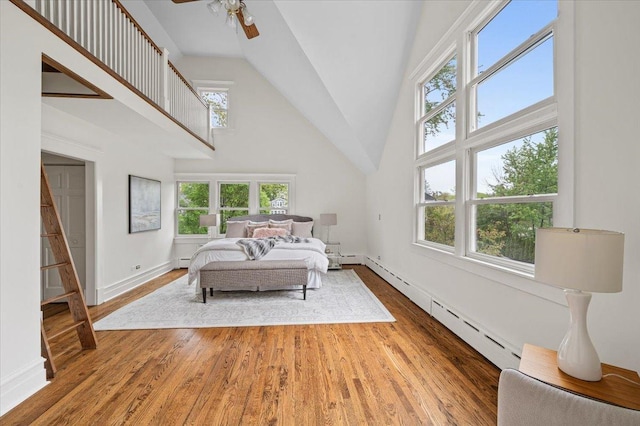820 Lake Ave, Wilmette, IL 60091 - bedroom featuring high vaulted ceiling, wood finished floors, a baseboard radiator, and baseboards