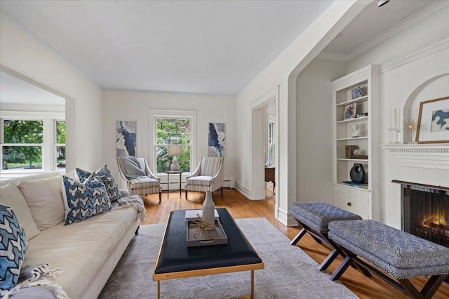 820 Lake Ave, Wilmette, IL 60091 - living room with a lit fireplace, wood finished floors, a baseboard heating unit, ornamental molding, and baseboards
