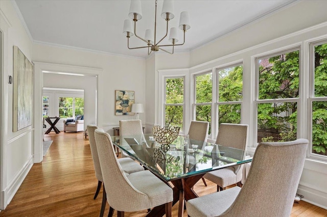 820 Lake Ave, Wilmette, IL 60091 - dining room featuring a chandelier, crown molding, light wood-style flooring, and a decorative wall