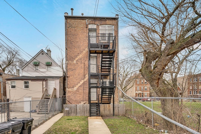 1234 S Karlov Ave, Chicago, IL 60623 - rear view of property featuring brick siding, a fenced front yard, and stairway