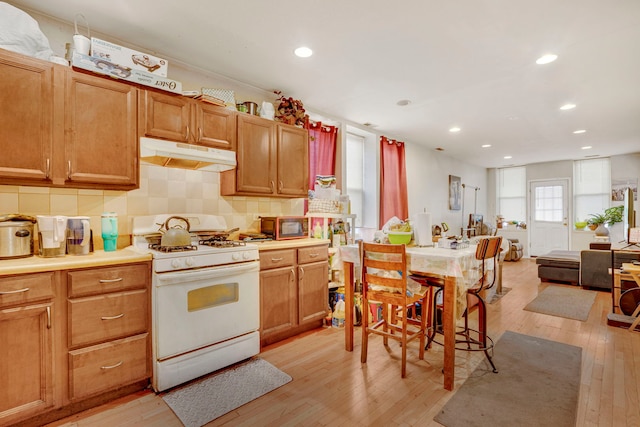 1234 S Karlov Ave, Chicago, IL 60623 - kitchen featuring recessed lighting, white gas range, under cabinet range hood, decorative backsplash, and light wood finished floors