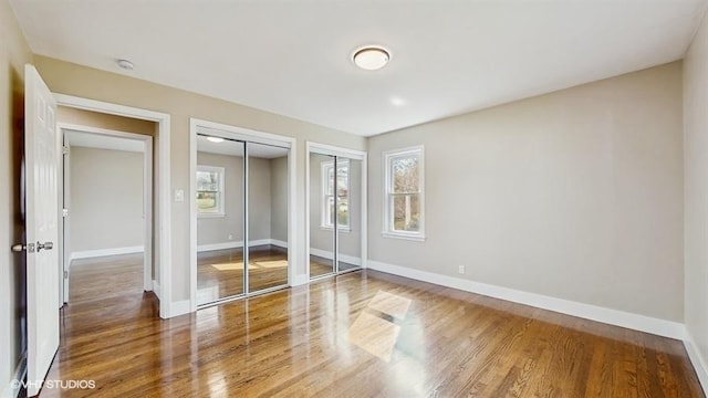 226 W Highland Dr, Chicago Heights, IL 60411 - unfurnished bedroom with wood finished floors, baseboards, and multiple closets