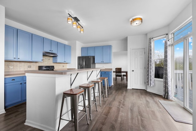 1904 Heron View Way, Round Lake, IL 60073 - kitchen featuring blue cabinets, black fridge with ice dispenser, under cabinet range hood, stove, and dark wood finished floors