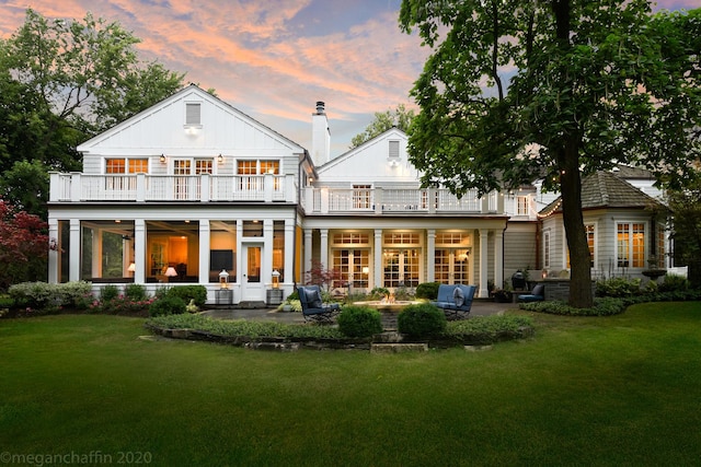 280 Old Farm Rd, Northfield, IL 60093 - back of property at dusk with a balcony, a patio area, a yard, and french doors