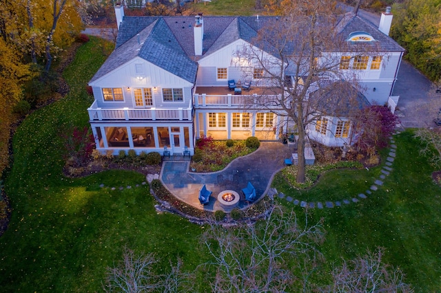 280 Old Farm Rd, Northfield, IL 60093 - back of house with a balcony, a chimney, a lawn, and board and batten siding